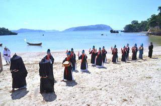 全身黒ずくめのアンガー行列が厳かに入場した西表島の節祭＝26日午後、前泊海岸