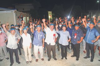 勝利に向けて「頑張ろう」を三唱する前西原陣営の支持者ら＝30日夜、祖納の後援会事務所