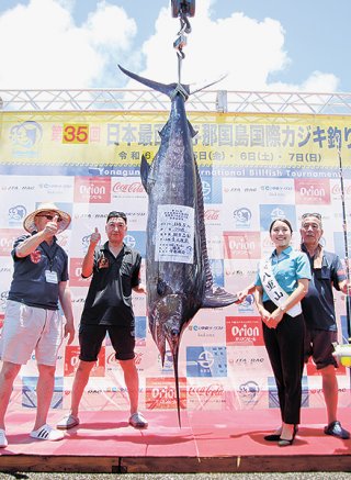 初日トップの114・5㌔のクロカワカジキを釣り上げたチーム「旗魚」の田中昌和さん（右）＝6日、久部良漁港