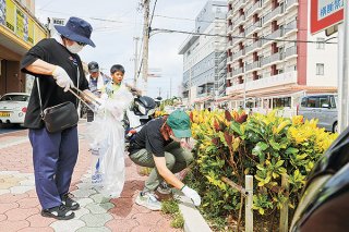 ユーグレナ石垣港離島ターミナル周辺で清掃活動を行う県ハイヤー・タクシー協会八重山支部の会員ら＝5日午前、730交差点付近