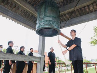 世界の恒久平和を願って鐘を打ち鳴らす参列者ら＝６日午前、新栄公園内世界平和の鐘鐘楼