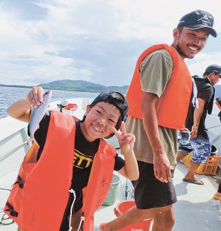 釣り上げたグルクンに大喜びの子どもたち＝１０日午前、名蔵湾