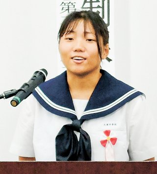 「託されるバトン」の演題で主張する浅田璃亜南さん。最優秀賞を獲得した＝7日午後、竹富町役場大会議室