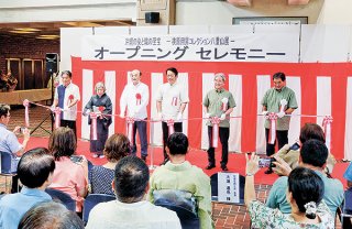 開館を前にテープカットを行う主催・協力団体の代表ら＝2日午前、市民会館中ホールロビー