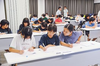 算数・数学フェスティバルでチームで話し合いながら問題に挑む小学生の児童ら＝9日午後、石垣市役所大会議室