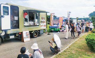 八重山の産業まつりに出店した石垣島キッチンカー協会所属の事業者ら＝5日、石垣市総合体育館