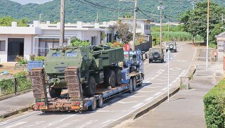 川原集落内を走行し、陸上自衛隊石垣駐屯地に向かう米軍の高機動ロケット砲システム「ハイマース」を載せたトレーラー＝13日午前