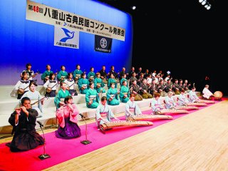 第1部の座開きで「鷲ぬ鳥節」を斉唱する新人・優秀・最優秀賞合格者ら＝19日夜、市民会館大ホール