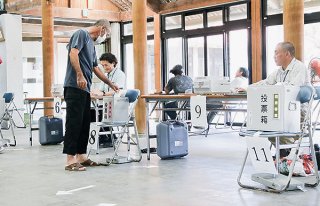 竹富町内で実施された繰り上げ投票で投票する町民ら＝26日午前、竹富まちなみ館