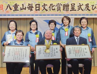 第40回八重山毎日文化賞正賞の大濵永亘氏（前列中）、特別賞の宮良芳和氏（同右）、活動賞のしぅまむに伝承研究会の亀井道子会長（同左）とメンバー（後列）＝11月30日午後、南の美ら花ホテルミヤヒラ