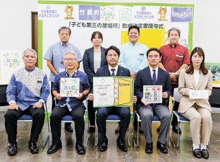 「子ども第三の居場所」の助成決定書を授与したＢ＆Ｇ財団の朝日田智昭常務理事（前列中央右）ら＝5日午後、竹富町役場