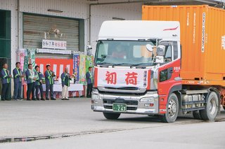 関係者の万歳に見送られながら初荷を積んだトラックが出発した＝8日午後、ＪＡ磯辺野菜集荷場